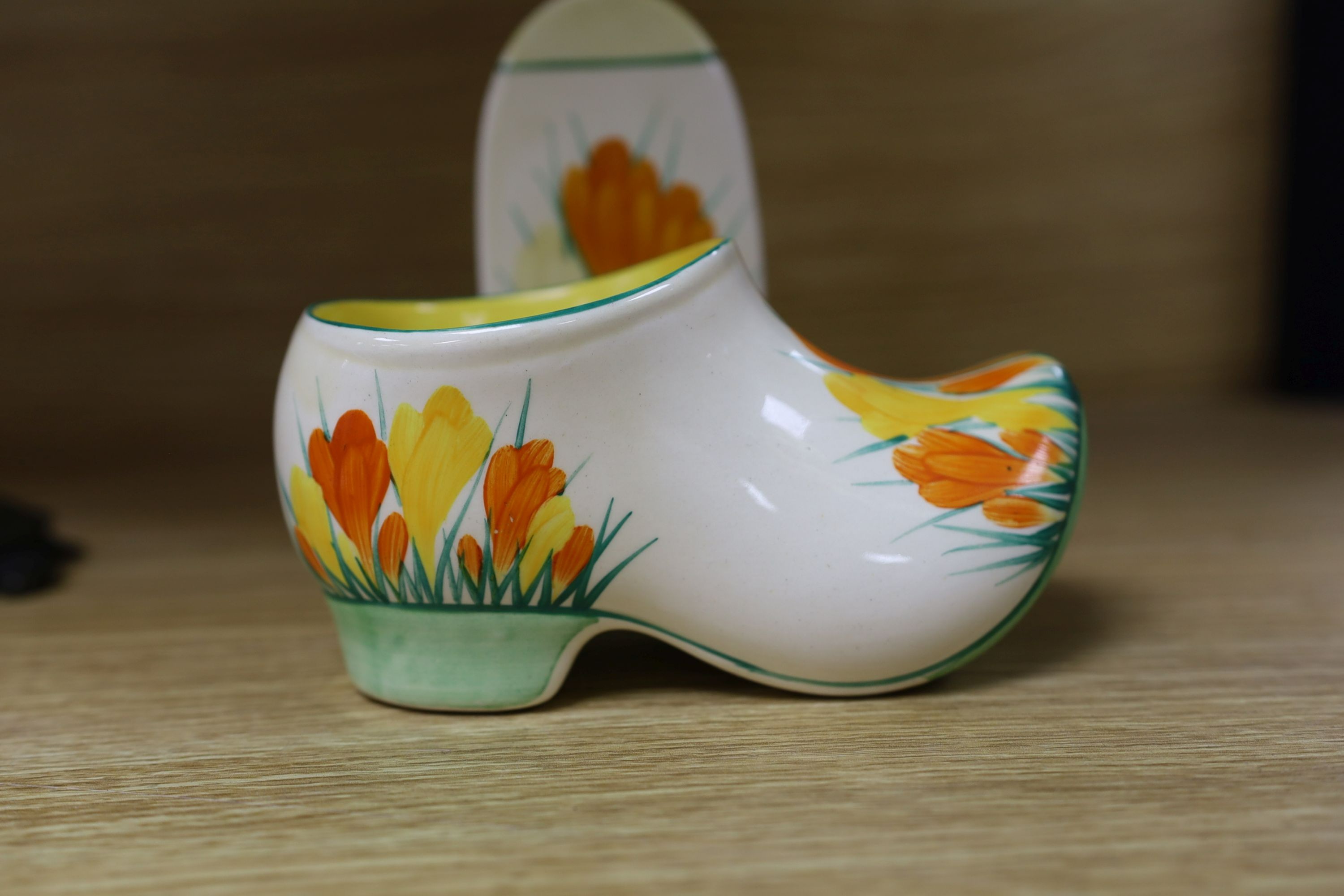 A Clarice Cliff sungleam crocus jam pot and cover, a sugar shaker and a Dutch clog ornament (3), jam pot and cover 10 cms high